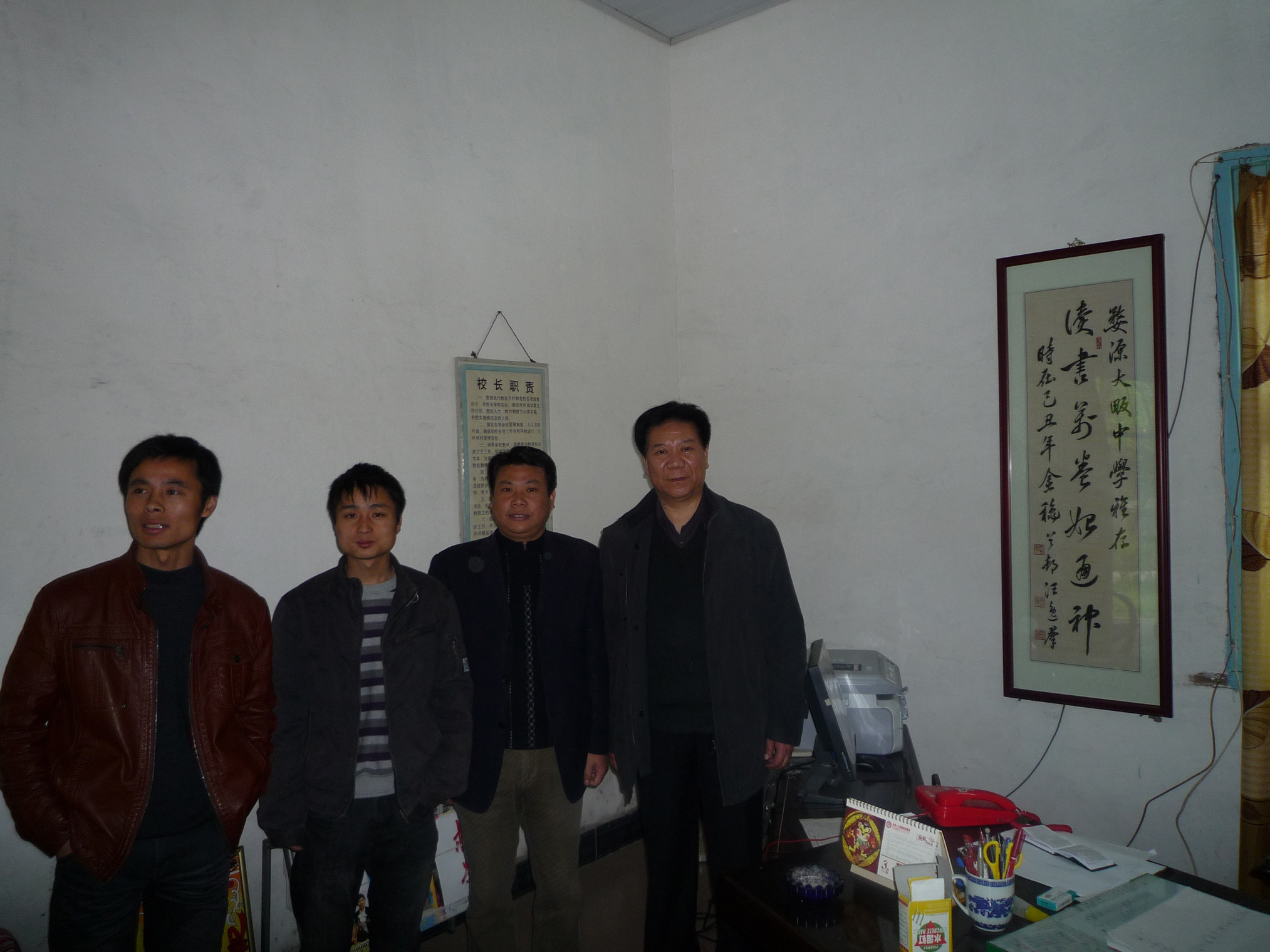 23a政委参观大畈学校，并在以前赠书的书法作品前留影.jpg