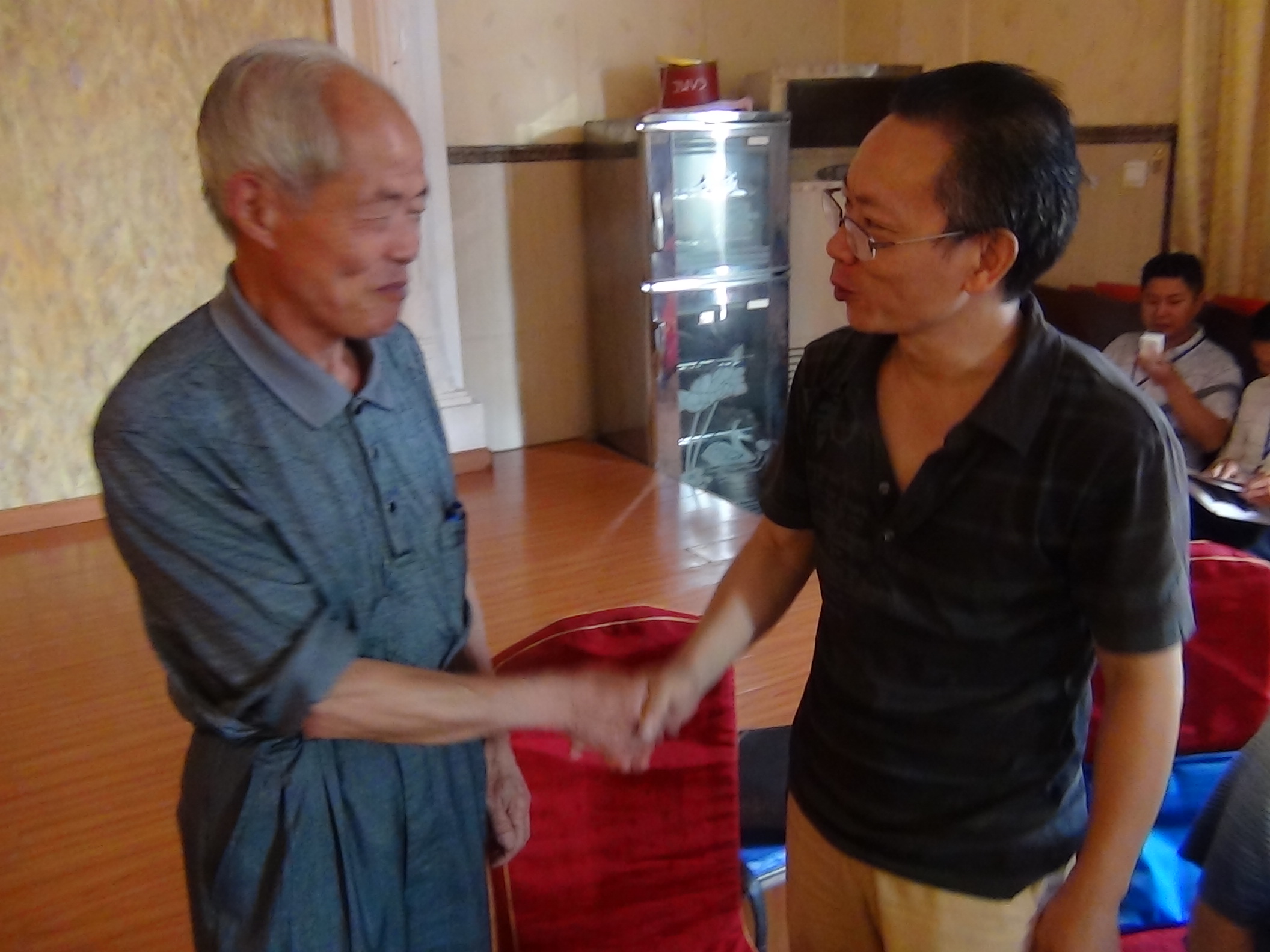 广仁在会上与金寨汪氏越国堂汪达梧先生亲切握手